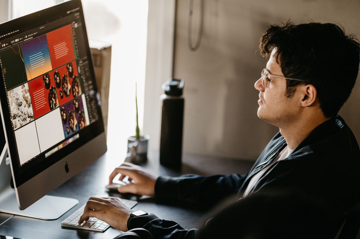 Designer laying out magazine pages on a large monitor